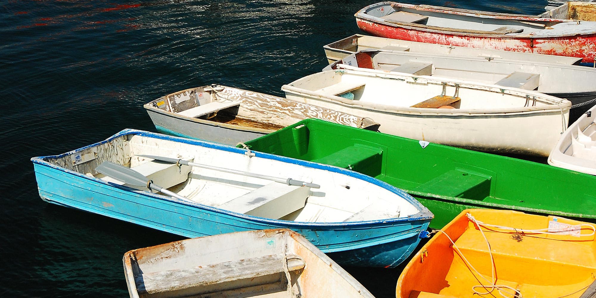 Colorful dories tied up alongside a pier
